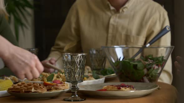 family having dinner at the table indoor at home alt