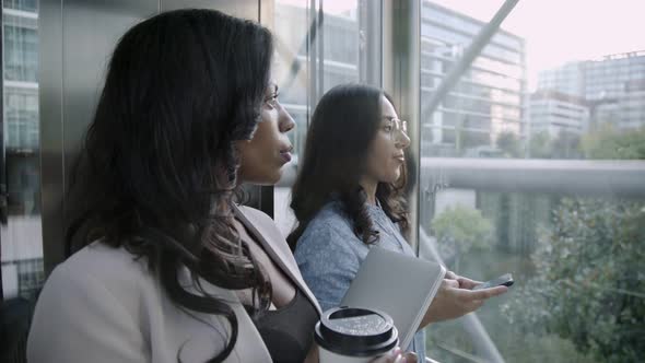 Confident Multiethnic Businesswomen Talking in Elevator alt