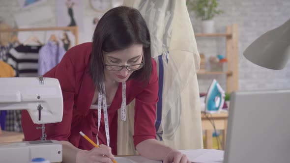 Young Fashion Designer Draws a Sketch Close Up alt