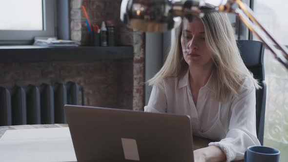 Young Woman Works for a Laptop in the Office Make the Business Correspondence alt