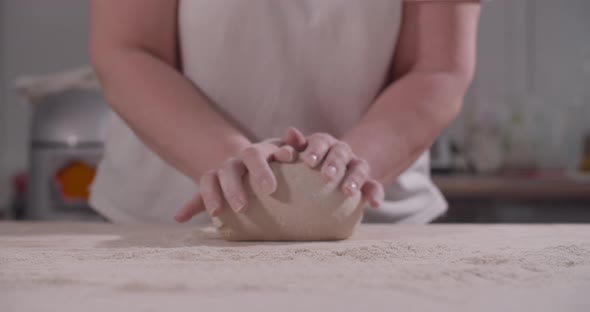 Female Hands Knead and Toss Dough on Kitchen alt