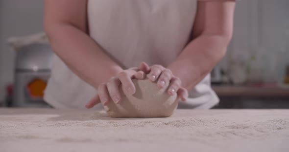 Female Hands Knead and Toss Dough on Kitchen
