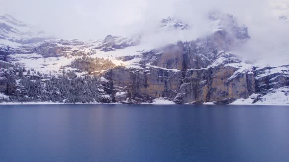 Oeschinensee Lake Switzerland Surrounded by Snow Covered Trees and Mountains alt
