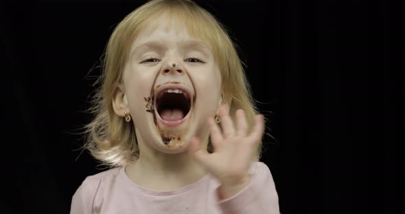 Child with Dirty Face From Melted Chocolate and Whipped Cream Smiling alt