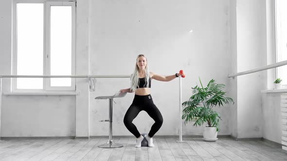 Woman Training in Studio Using Dumbbell alt