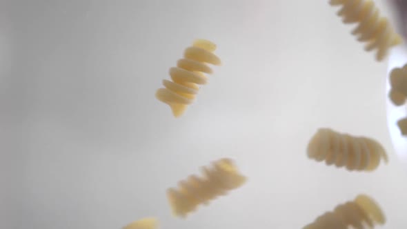 Macaroni of Fusilli are Falling on the Glass Close Up Food and Ingredients