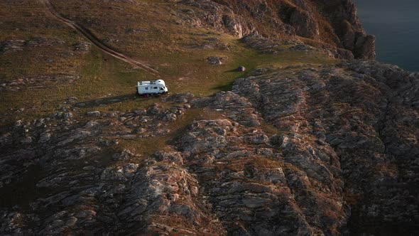 RV Camper Van on Mountains Landscape Near High Cliff Aerial Shot