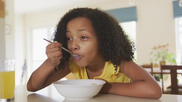 Front view of African american girl eating cereals alt