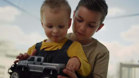 Two Brothers Spending Time Together at Home. Older Brother Kissing Younger. alt