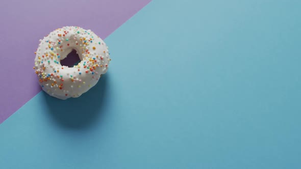 Video of donuts with icing on blue and purple background alt