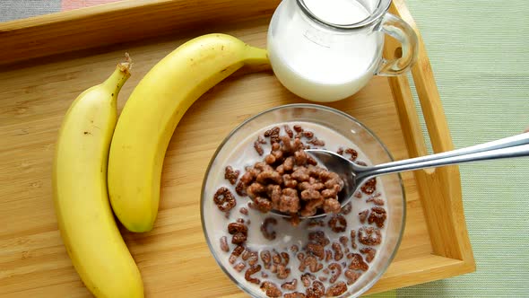 HD video, chocolate cornflakes in the form of an alphabet with milk in a bowl. Top view of a breakfa