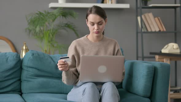 Woman Making Online Payment on Laptop on Sofa alt