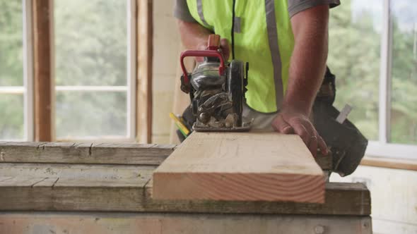 Closeup of construction worker cutting with circular saw