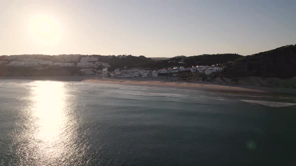 Sun reflecting in the ocean while flying towards Salema beach in Portugal alt