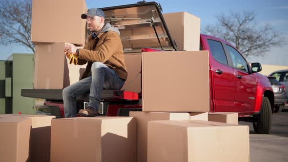 Courier Unloading Shipping Boxes Parcel From His Truck alt