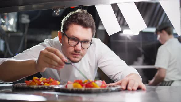 Chef Using Tweezers for Serving Salad alt