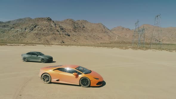 Aerial View Two Exotic Sports Cars in the Middle of Dry Desert with Mountain USA alt