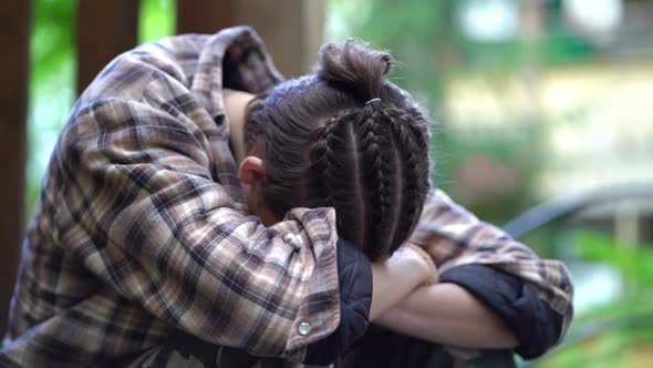 Sad Upset Boy Sitting with His Head Bowed alt