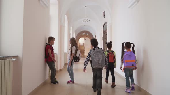 Children Talking in School Hallway During Break.