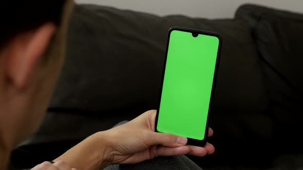 Big green screen display mobile phone in female hand 4K close-up video