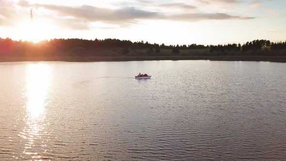 Family on a Pedal Boat at Sunset Aerial Shot.