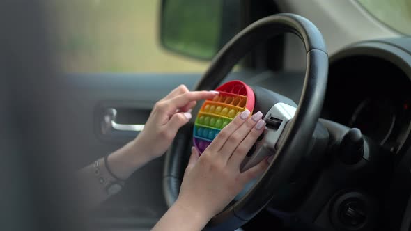 Woman Using Pop It or Simple Dimple in Car