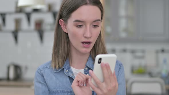 Portrait of Upset Young Woman Reacting To Loss on Smartphone alt