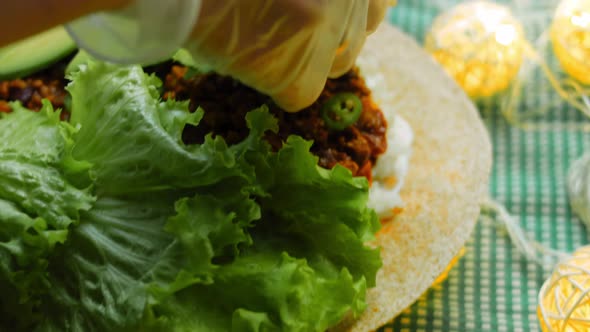 The Chef Arranges the Avocado Slides Over the Burrito alt