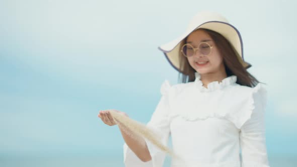 Cute Asian girl walking on the beach by the beach. alt