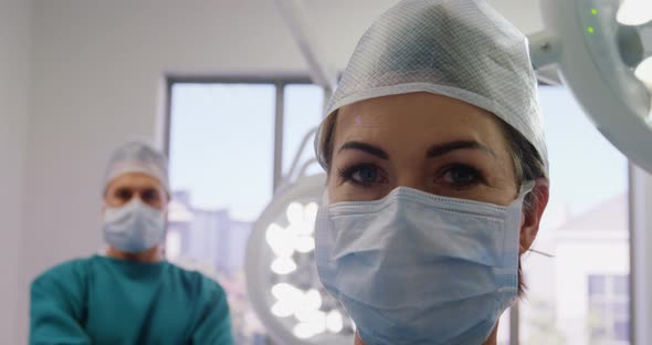 Portrait of surgeons standing with arms crossed in operation room alt