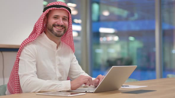 Arab Businessman with Laptop Smiling at Camera  alt