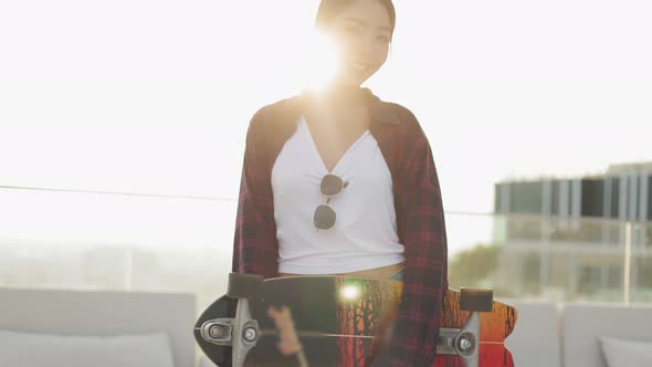 Attractive Asian woman smiling  play skateboard outdoor alt