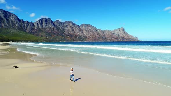 Aerial of woman walking on beautiful beach 4k alt