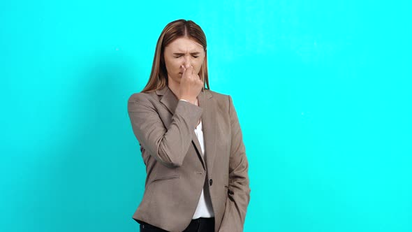 Intelligent Young Woman, in Business Style, Who Closes Her Nose with Her Fingers alt