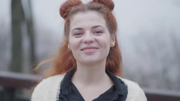 Close-up Face of Beautiful Redhead Woman Looking at Camera and Smiling alt
