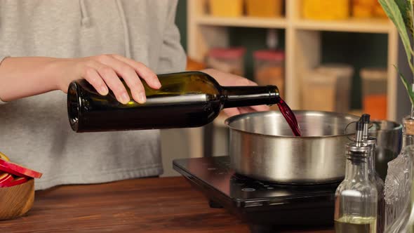 Woman Cooking Mulled Wine Gluhwein with Apples and Oranges Recipe alt