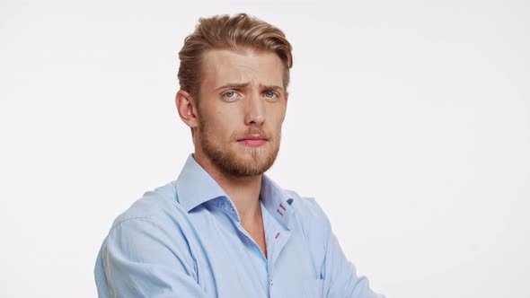 Serious Young Caucasian Male with Blue Eyes and Brown Beard Approves on White Background alt