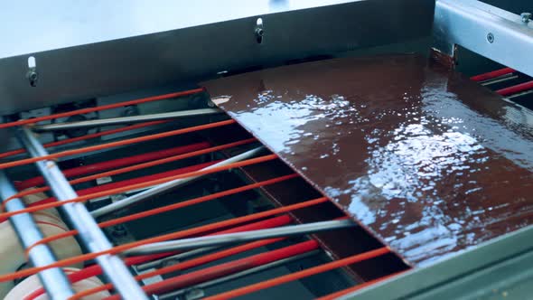 Waffle Layers Covered in Chocolate Are Moving Through the Machine alt