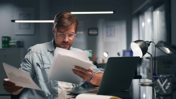 Businessman Reading Documents Sitting at Desk in Modern Office alt