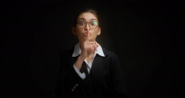 Young Businesswoman Shows a Shh Gesture Asks for Silence