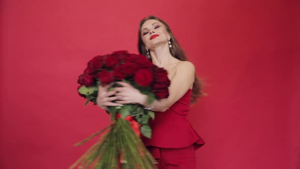 Gorgeous Woman in Red Dress Spinning with Bouquet of Roses