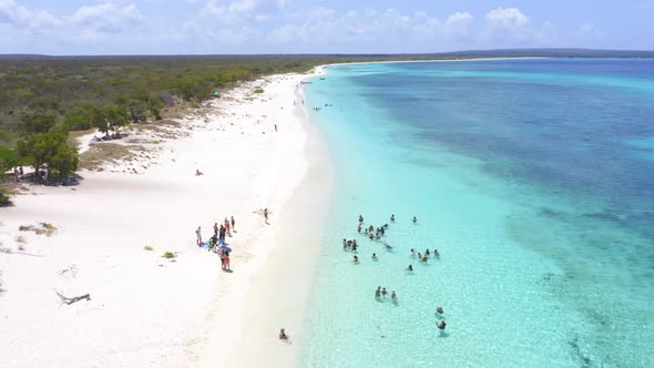 Tourists enjoy crystal clear turquoise waters of Bahia de Las Aguilas alt