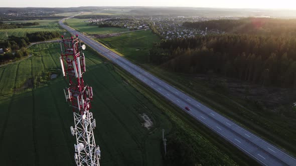 Mobile communication tower near a road in a picturesque countryside. alt