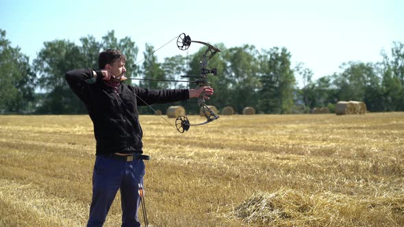 Archery Sport Man Shooting From a Bow Outdoors in the Field