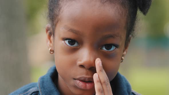 Cute Kid Telling Secret Quietly Closing Mouth with Hand Close Up African American Little Girl alt