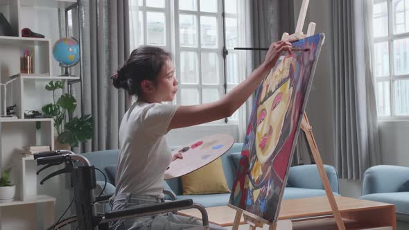 Talented Female Artist Sitting On Wheelchair Using Paint Brush She Creates With Oil Painting alt