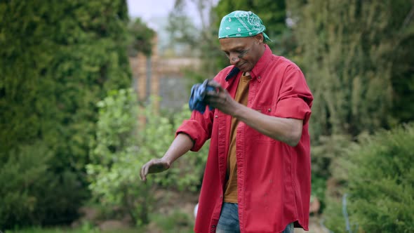 Tired African American Young Man Cleaning Dirty Hands with Cloth and Leaving alt