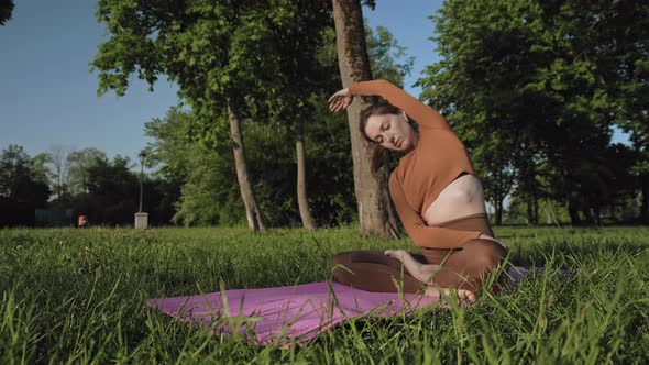 Woman practising yoga exercise in park outdoors