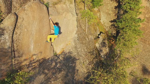 Top View of a Man Climbing a Rock Crack Without Insurance