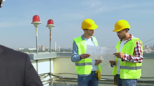 Happy Male Engineer in Helmet Smiling on Cam, Builders Discussing House Scheme